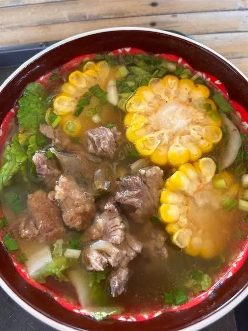 Hearty beef soup with corn served at the farm